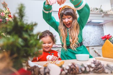 Festive Christmas Lodge with Elf and girl making gingerbread lodge