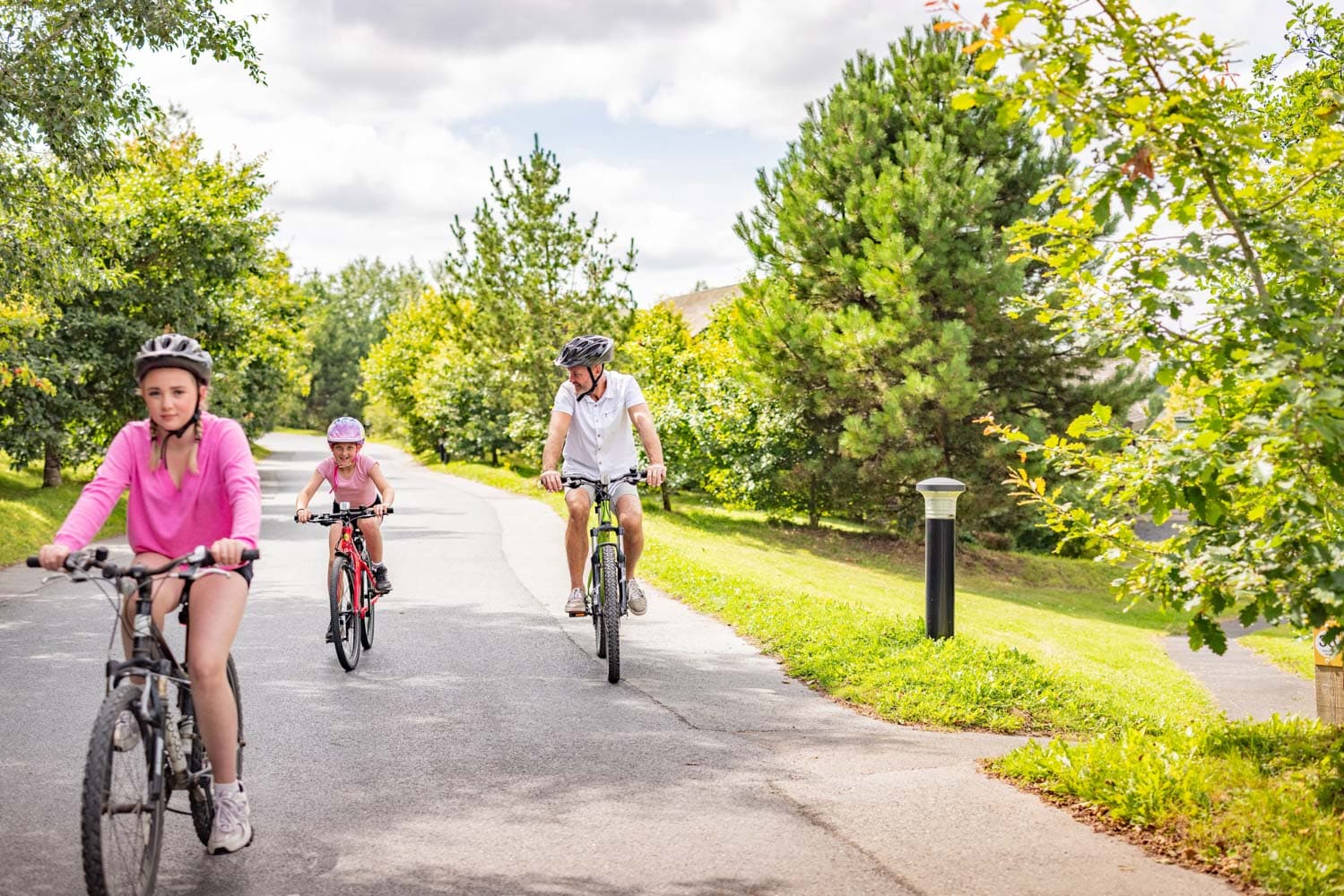 Family Cycling On Bikes in Summer