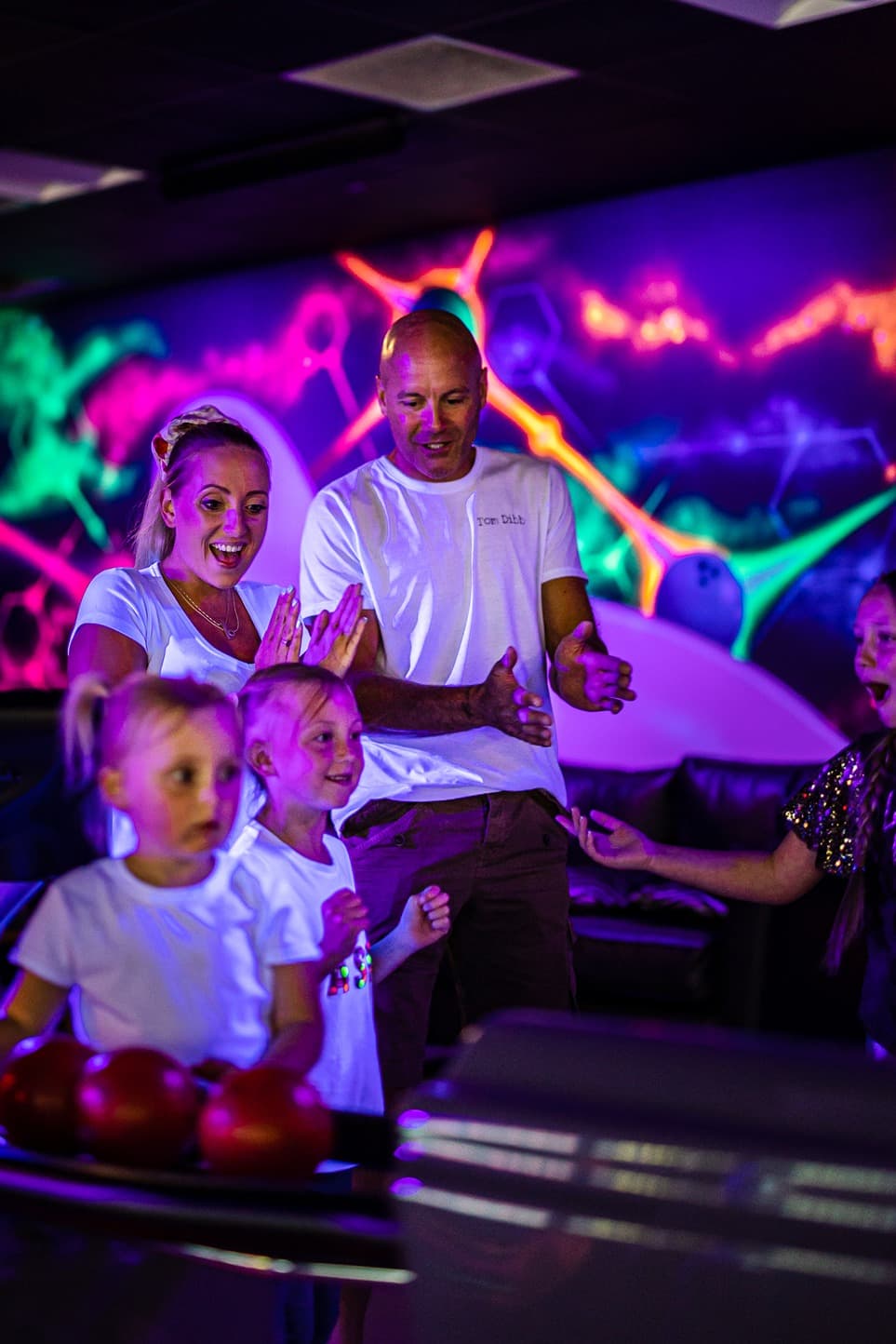 Family enjoying Glowzone Bowling in The Hive