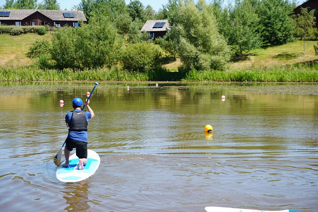 Paddleboard On Lake Kneeling