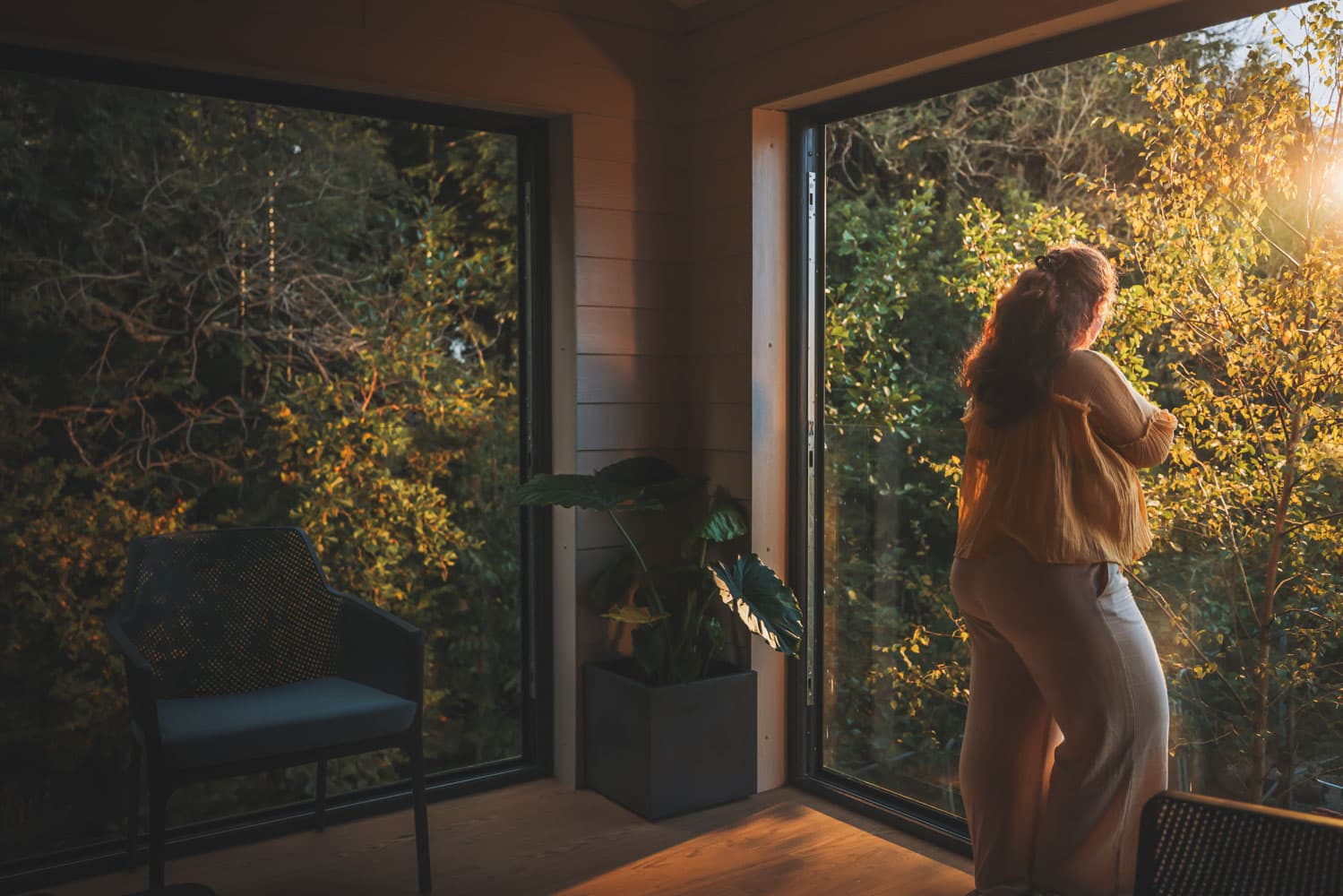 Woman Looking Out Of Balcony Into Woodland