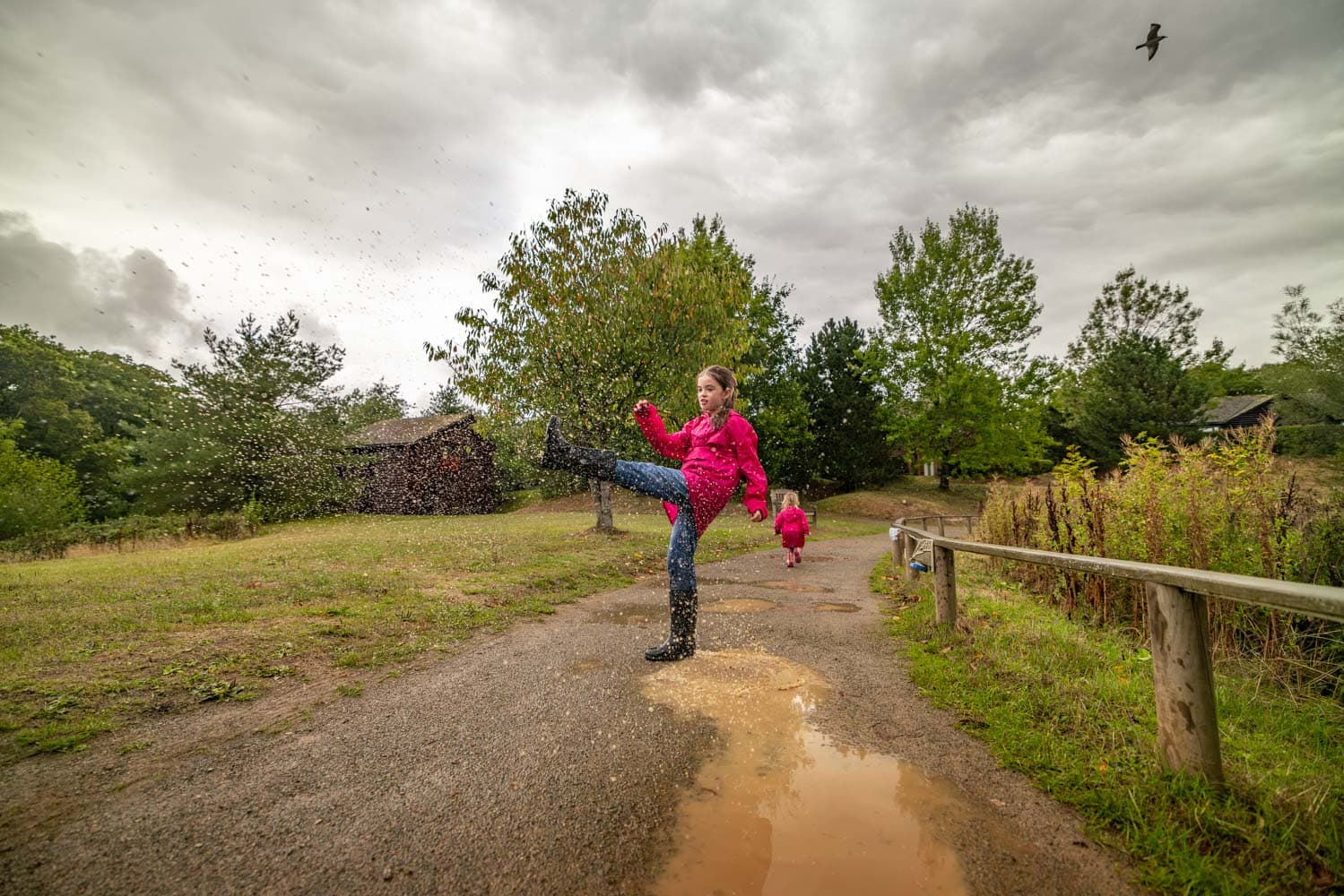 Girls Kicking Puddle Around Lake Autumn
