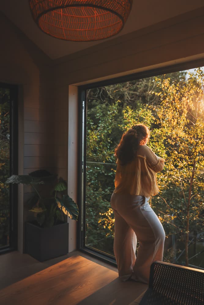 Woman Looking Out Of Balcony Into Woodland
